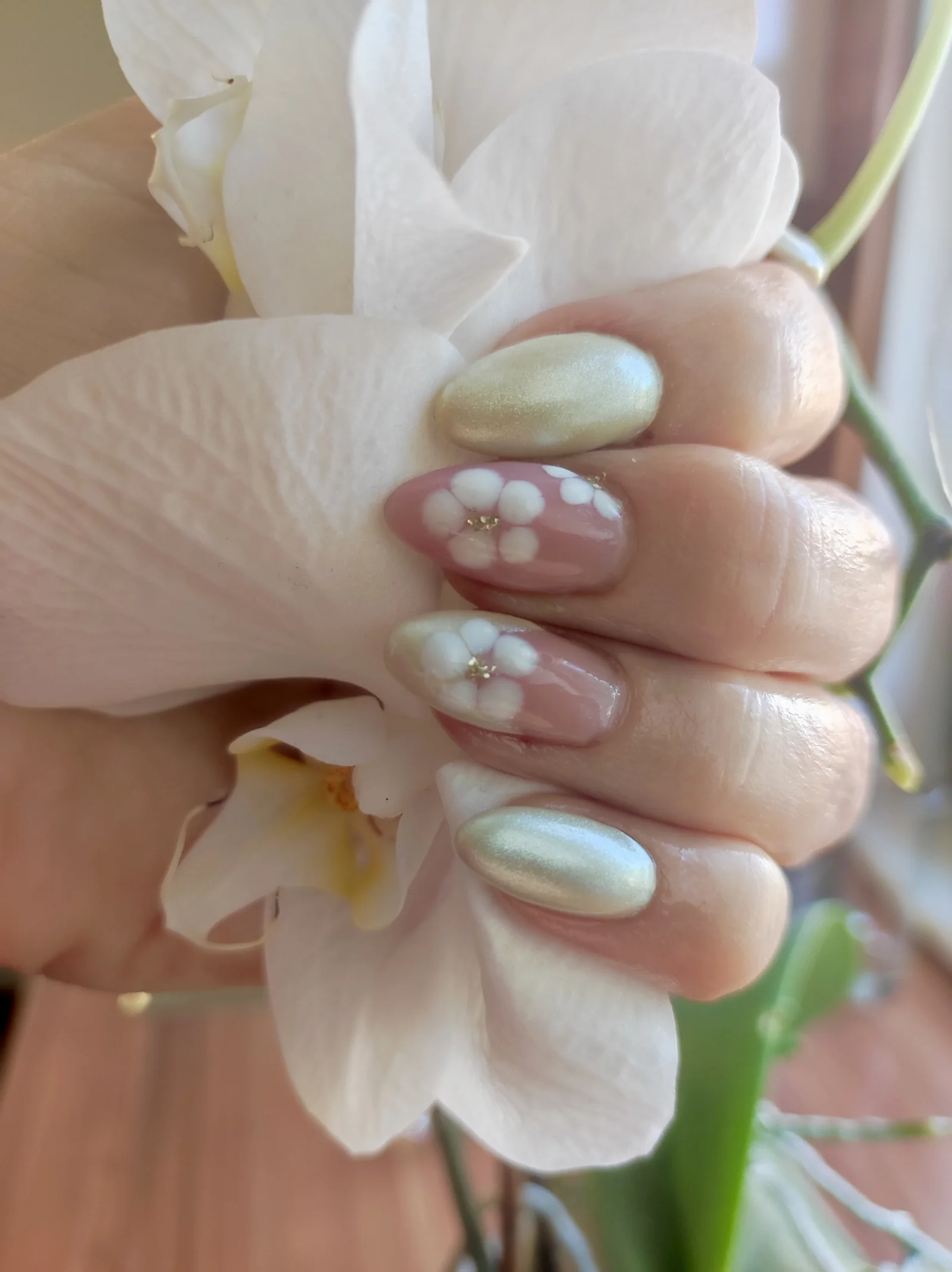 Nude-Nägel mit gemalten Blüten und Chrom-Akzent